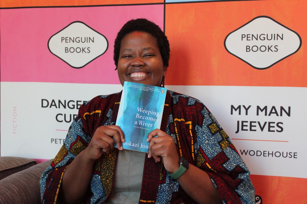 Siphokazi Jonas with her author copy of Weeping Becomes a River book